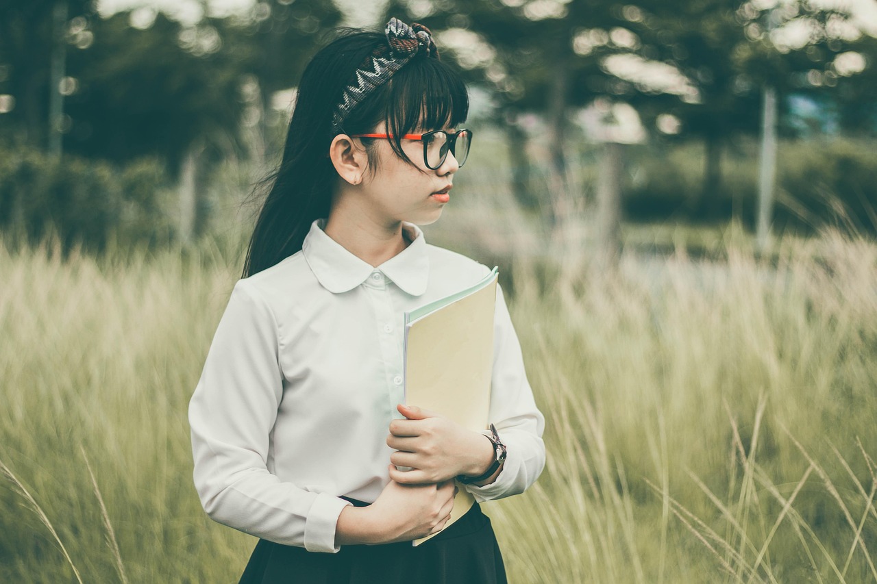 asian, student, book, child, girl, uniform, school uniform, eyeglasses, nature, field, grass, kid, looking away, outdoors, portrait
