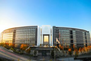 Panoramic view of a modern university building under a clear blue sky at sunset.